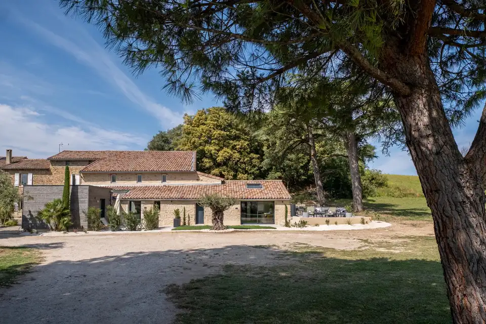 La maison familiale en pierre drômoise vue depuis l'allée, sous les pins